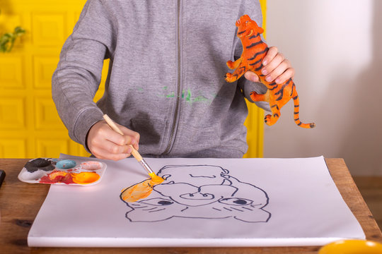Boy with brush painting a tiger