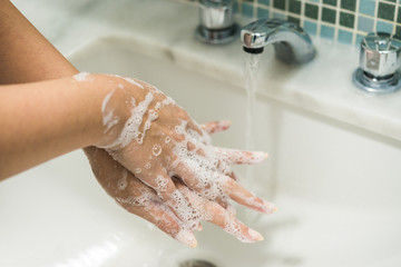 Fototapeta premium Young woman washing her hands with antibacterial disinfectant soap for prevention of coronavirus and other pandemic and epidemic diseases