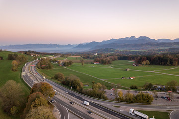 Top down aerial view of freeway interstate road with moving traffic cars in rural area.
