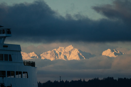 The Olympic Mountain range through the clouds at sunrise from Seattle