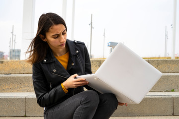 Female student looking at her broken computer.