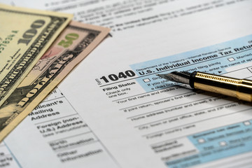 Tax form with pen and dollar banknote. document are mock-up