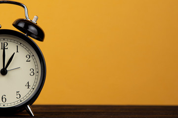 Alarm clock on yellow background