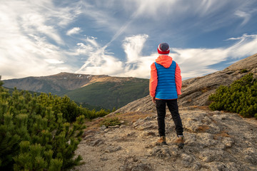 Fototapeta premium Young child boy hiker standing in mountains enjoying view of amazing mountain landscape.