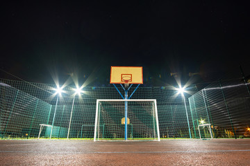 Outdoors mini football and basketball court with ball gate and basket surrounded with high...