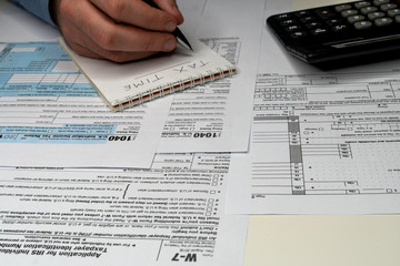 Obraz premium A person is completing the tax form with a pen.