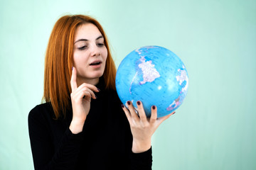 Portrait of a happy young woman holding geographic globe of the world in her hands. Travel destination and planet protection concept.
