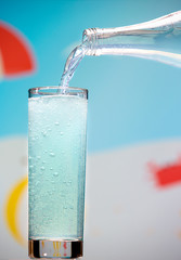 Agave carbonated drink pours from a bottle into a glass