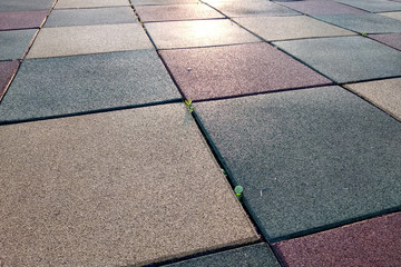 Close up of soft rubber tiles for covering at outdoor gym of stadium at preschool yard.