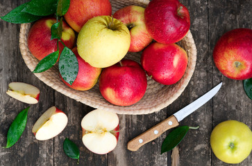 .basket with apples and knife on a wooden background