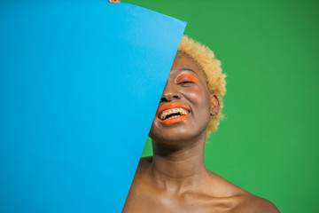 Half face portrait of young african american girl wearing eye shadow cosmetics with a cheerful...