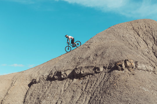 Side view of Mountainbiker riding steep desert terrain