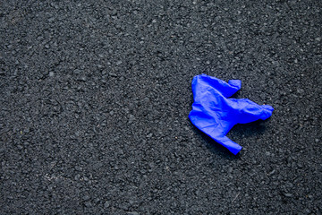 A Used Blue Medical Glove in a Parking Lot