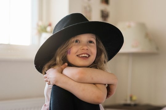 portrait of a young girl smiling at home playing dress up