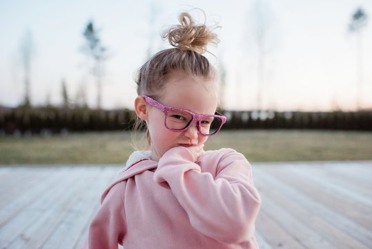 portrait of a young girl pulling funny faces with sparkly glasses on