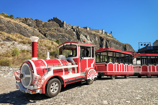 Red excursion train in old town of Sion Valais Switzerland