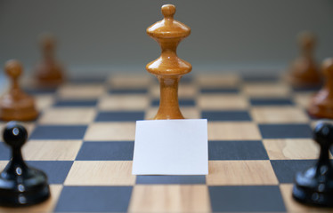 Concept chess pieces express social distancing with blank white board in front of the center piece.