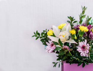 Bouquet of flowers in a wooden box on a white background. Holiday card concept.