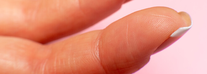 female hand finger inner side, close-up on a pink background. fingertips