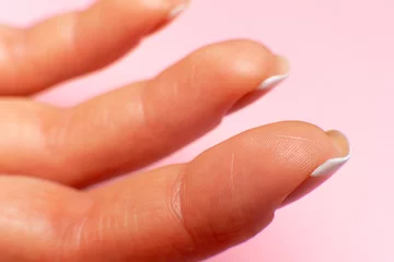 three fingers inside on a female hand, close-up. pink background.