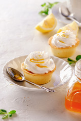 Tartlets with lemon kurd and italian meringue on a white plate