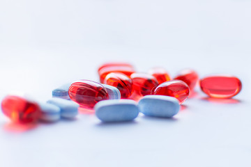 Red and blue capsules on white background. Traditional medicine treatment.