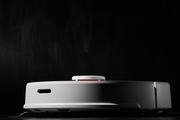 white Robotic vacuum cleaner on black background side view