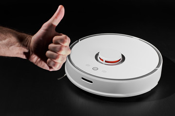 white Robotic vacuum cleaner on black background and thumb up