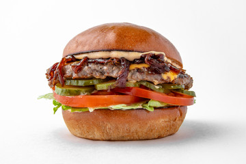 Tasty hearty hamburger with vegetables, cheese and herbs for take away or food delivery isolated on a white background.