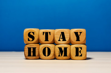 Stay Home on wood cube with blue background