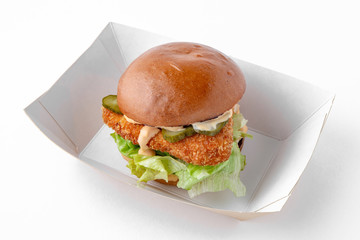 Tasty hearty hamburger with vegetables, cheese and herbs in eco paper packaging for take away or...