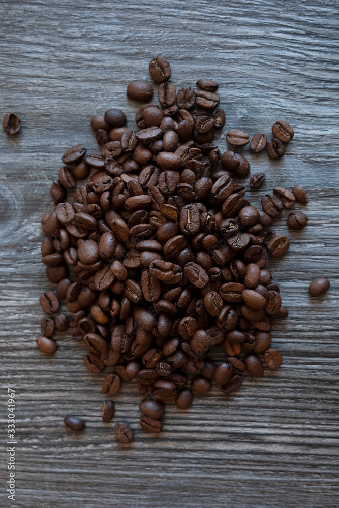 Wall mural Coffee beans on a wooden table, top view.