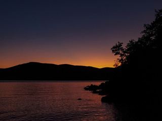 Fototapeta na wymiar Sunset sky and mountain silhouette at Magneli Beach, Krk, Croatia