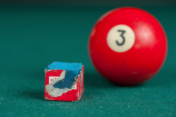 Billiards balls and cue on billiards table. Billiard sport concept. Chalk block on biliard table.