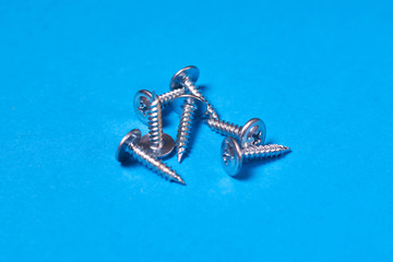Screws scattered on a blue background.