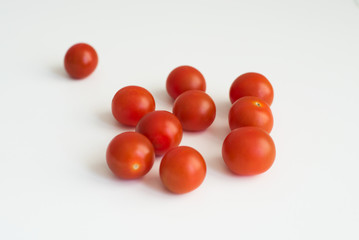 A handful of fresh ripe cherry tomatoes close-up on white background top view. A delicious and healthy ingredient for sauces, ketchup, pizza, and vegetarians