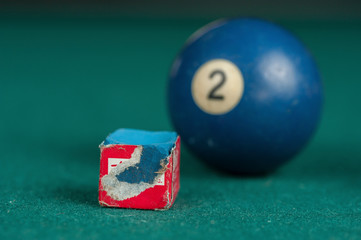 Billiards balls and cue on billiards table. Billiard sport concept. Chalk block on biliard table.