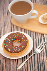 Dessert, Donuts, chocolate and strawberry circles, sugar and cream on Donuts and hot coffee cups, preparation for a break or party on the wooden table background.