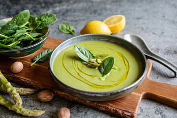 Creamy asparagus and spinach soup in a ceramic plate - obrazy, fototapety, plakaty
