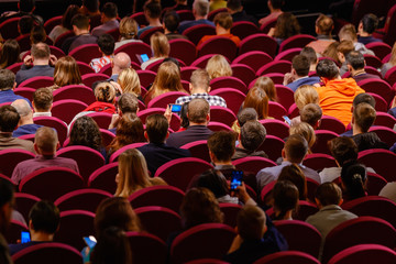 Business conference attendees sit and listen