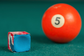 Billiards balls and cue on billiards table. Billiard sport concept. Chalk block on biliard table.