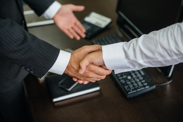 Close-up of the partners ' handshake, completion of the transaction in the office. Business