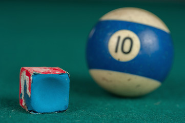 Billiards balls and cue on billiards table. Billiard sport concept. Chalk block on biliard table.