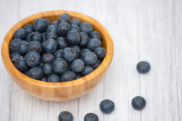 Bio Fruit Blueberry in bowl wood health and diet with vitamin c in close-up on the wood table.