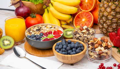Group Fruits Breakfast mixed vegetables with salad bowl, nuts bowl, strawberry, banana, and pineapple, orange juice,  vitamin c in food  nature for health and diet in the top view on the wood table.