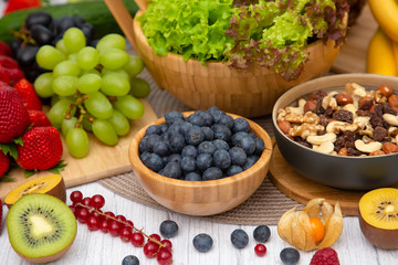 Group Fruits Breakfast mixed vegetables with salad bowl, nuts bowl, strawberry, banana, and pineapple, orange juice,  vitamin c in food  nature for health and diet in the top view on the wood table.