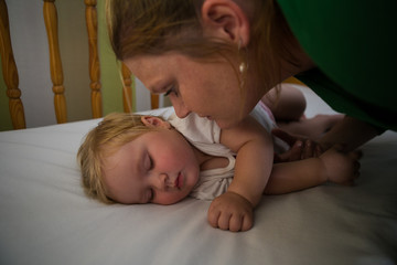 Close up image of a toddler girl sleeping in a cot