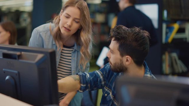 University Library: Focused Bright Caucasian Girl and Talented Hispanic Boy Study for Exams, Work on Assignment, Use Computer, Point at the Screen, Talk, Look for Solution, Explain Subject