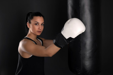 Female kickboxer training with a punching bag 