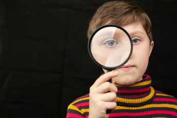 Girl looks through a magnifier.